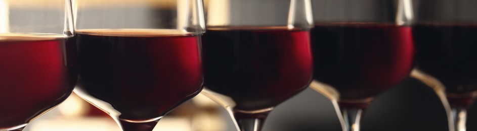 Image of Glasses with tasty red wine, closeup view. Banner design