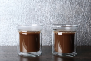 Glass cups with tasty coffee on wooden table