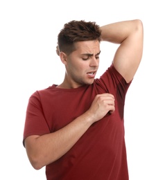 Young man with sweat stain on his clothes against white background. Using deodorant