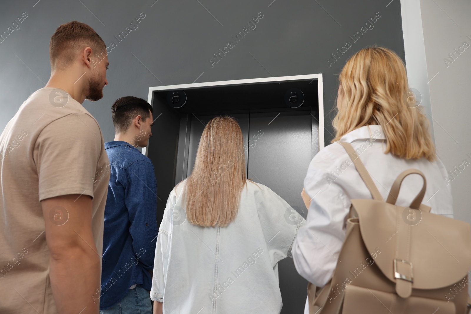 Photo of Group of people waiting for elevator in modern building