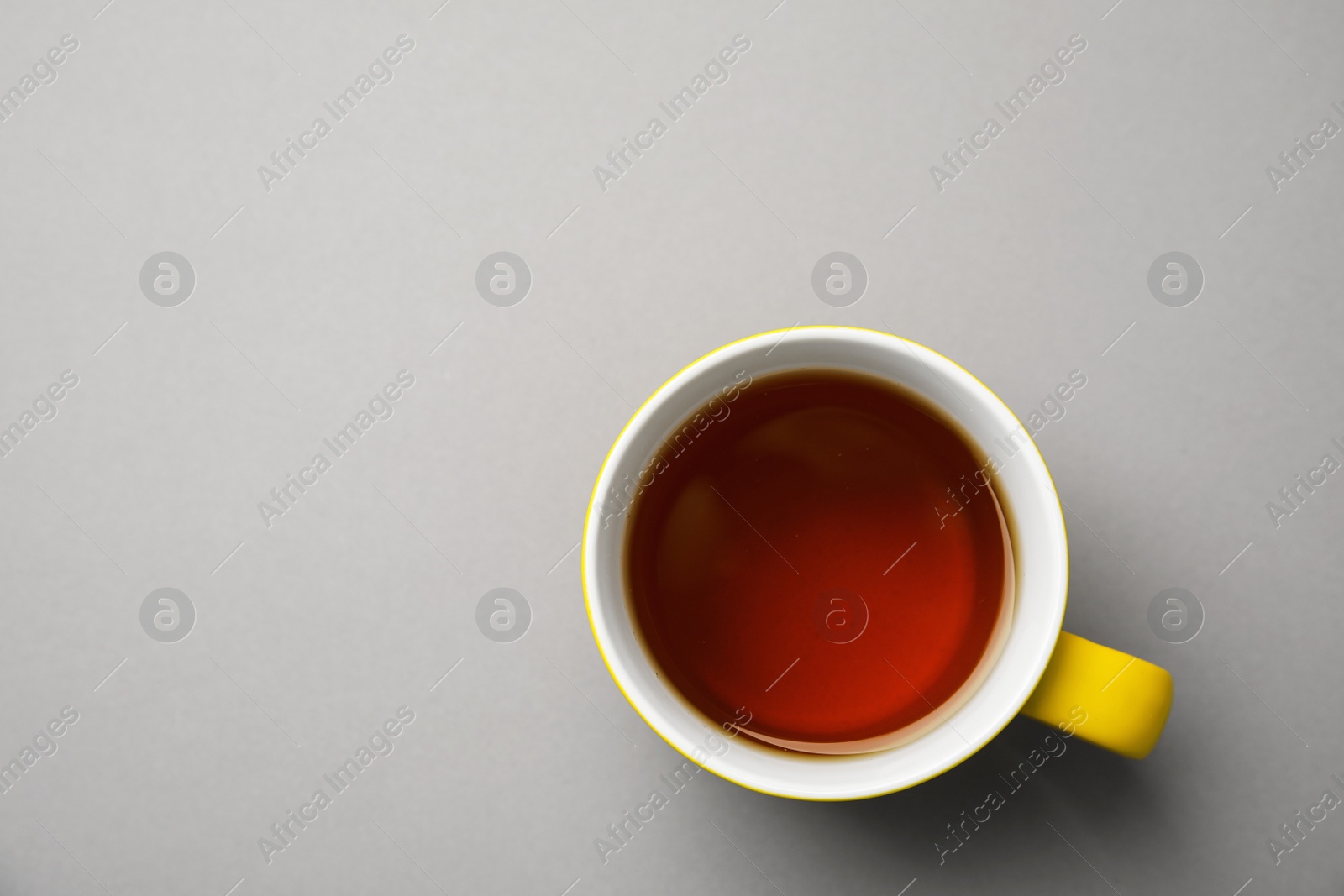 Photo of Cup of black tea on color background, top view