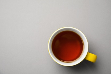 Photo of Cup of black tea on color background, top view