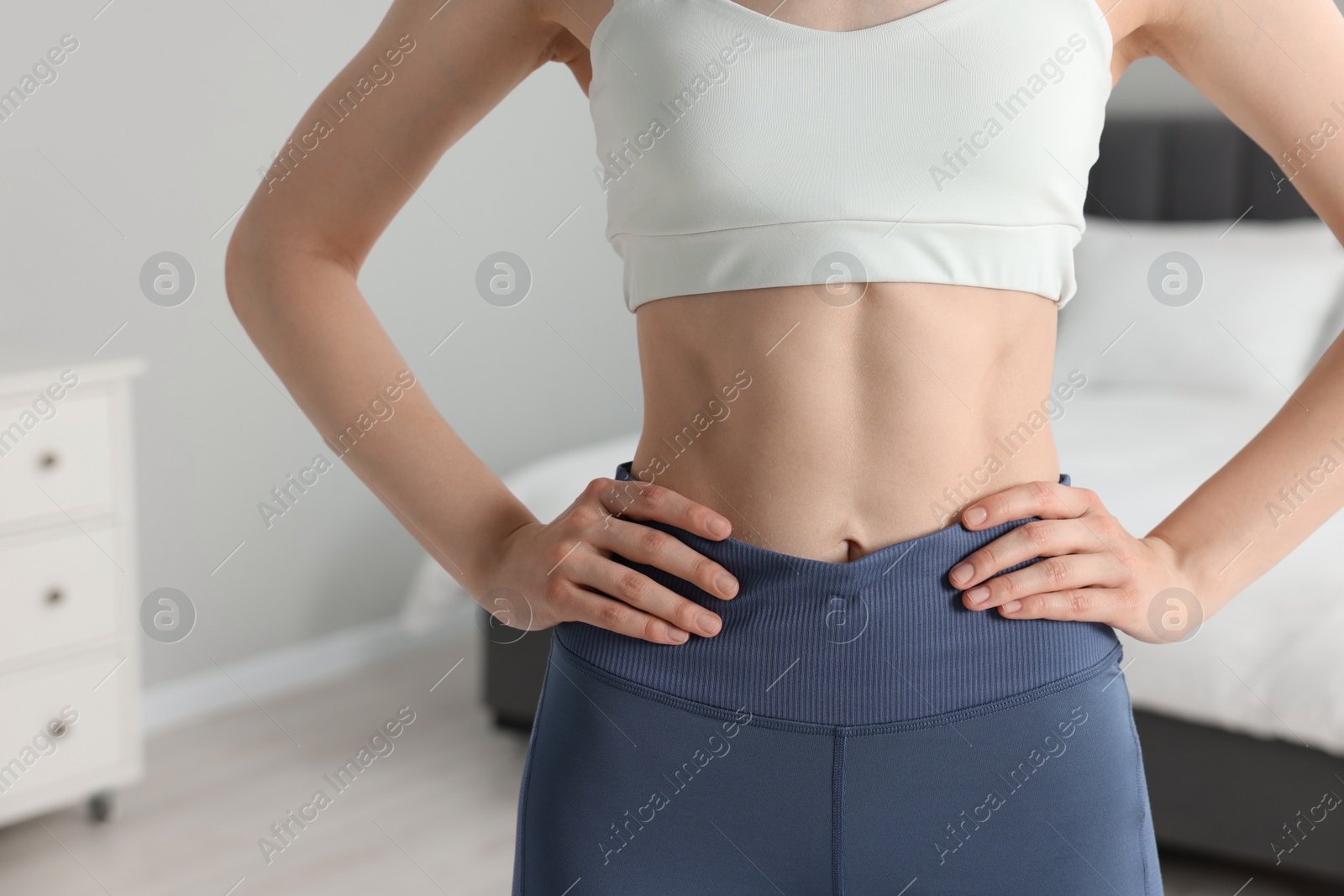 Photo of Woman wearing sportswear in bedroom, closeup. Space for text