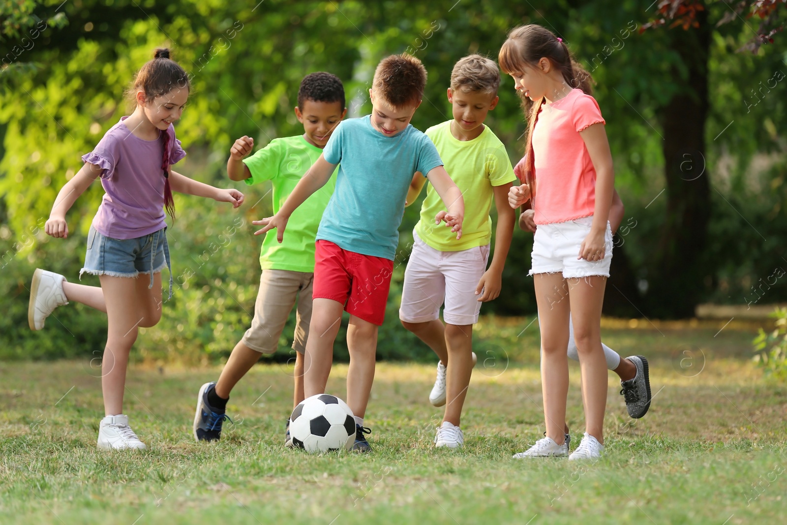 Photo of Cute little children playing with soccer ball in park