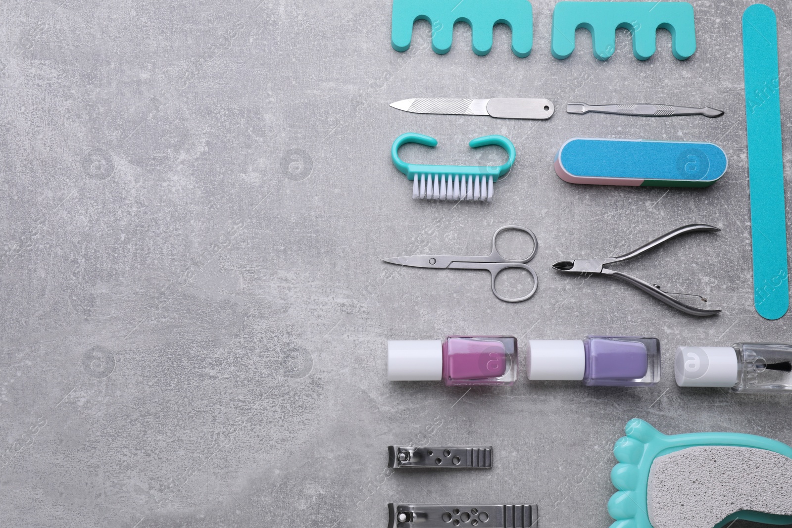 Photo of Set of pedicure tools on light gray table, flat lay. Space for text