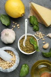 Photo of Delicious pesto sauce and ingredients on grey table, flat lay