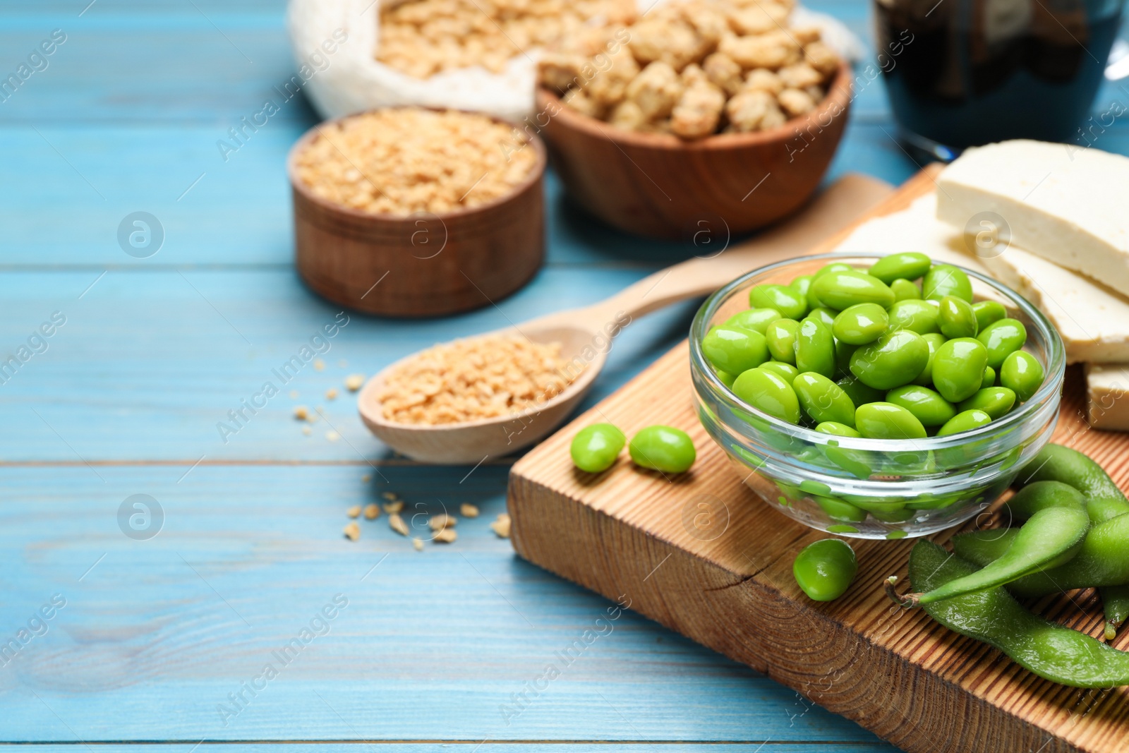 Photo of Fresh green soy beans and other organic products on light blue wooden table. Space for text