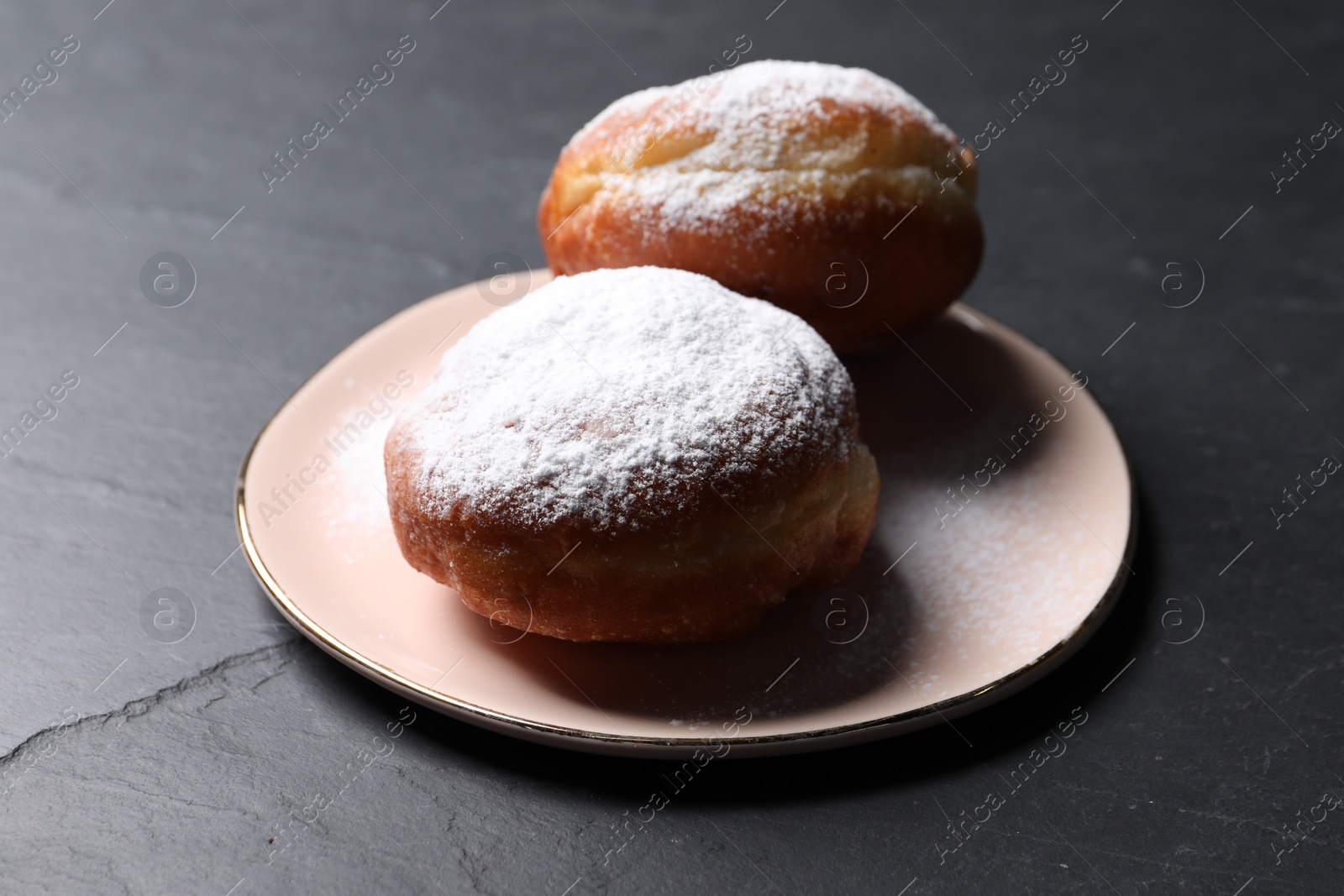 Photo of Delicious sweet buns on dark gray table, closeup