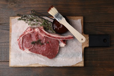 Photo of Raw meat, thyme and marinade on wooden table, top view