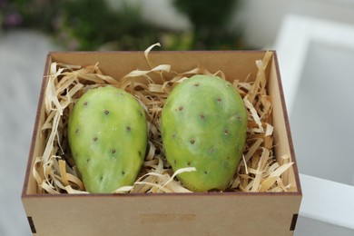 Photo of Delicious fresh ripe opuntia fruits in wooden box outdoors