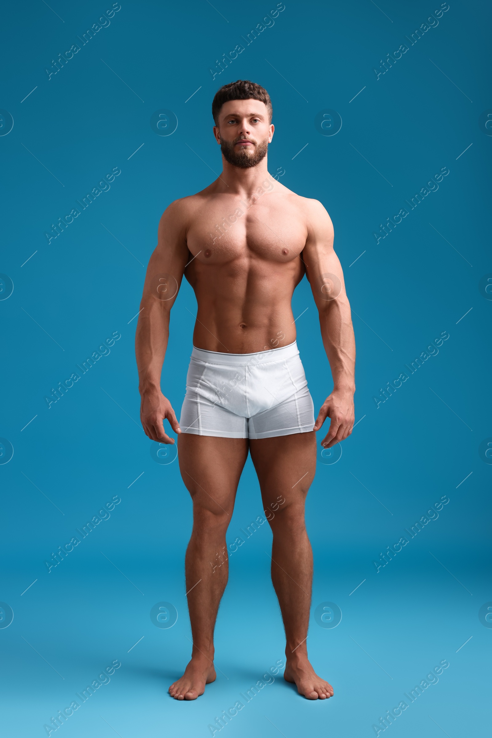 Photo of Handsome muscular man on light blue background. Sexy body