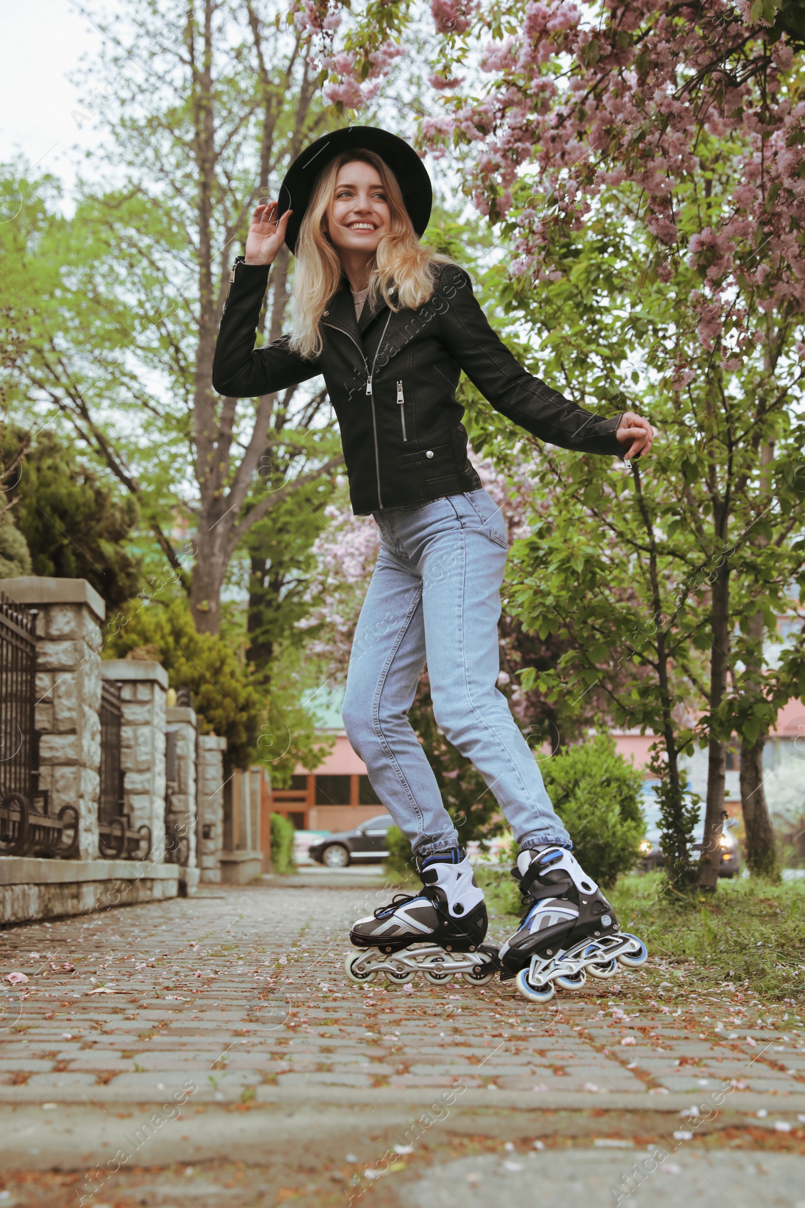 Photo of Young woman roller skating on spring day