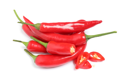 Photo of Cut and whole red hot chili peppers on white background