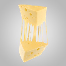 Image of Tasty cheese stretching in air on grey background