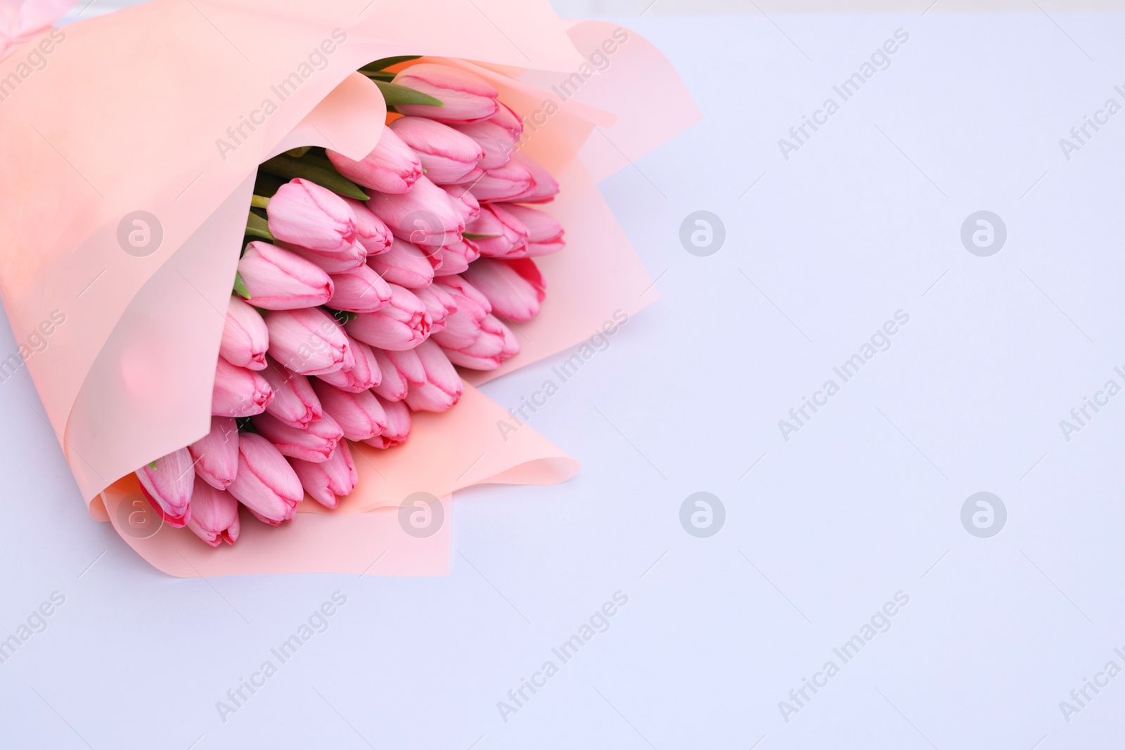 Photo of Bouquet of beautiful pink tulips on light grey background, space for text