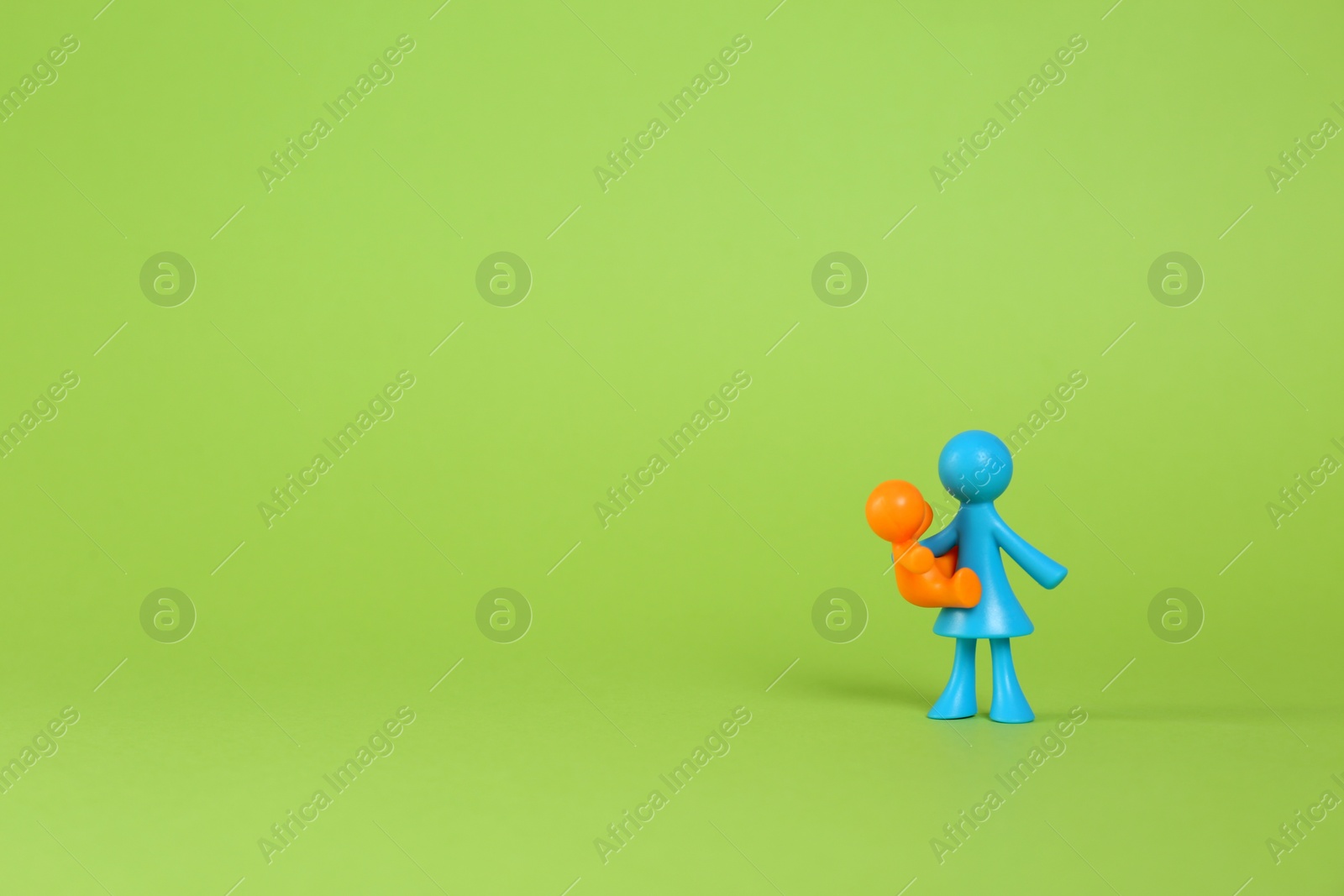 Photo of MYKOLAIV, UKRAINE - JANUARY 04, 2022: Colorful human figures on light green background, space for text. Surrogacy concept