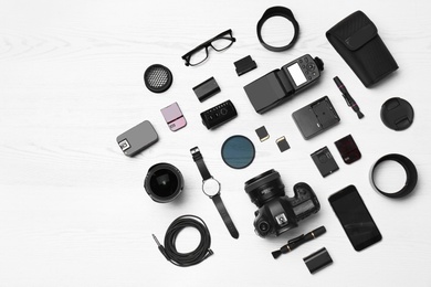 Flat lay composition with equipment for professional photographer on wooden background. Space for text