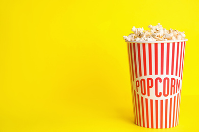 Tasty pop corn on yellow background, space for text