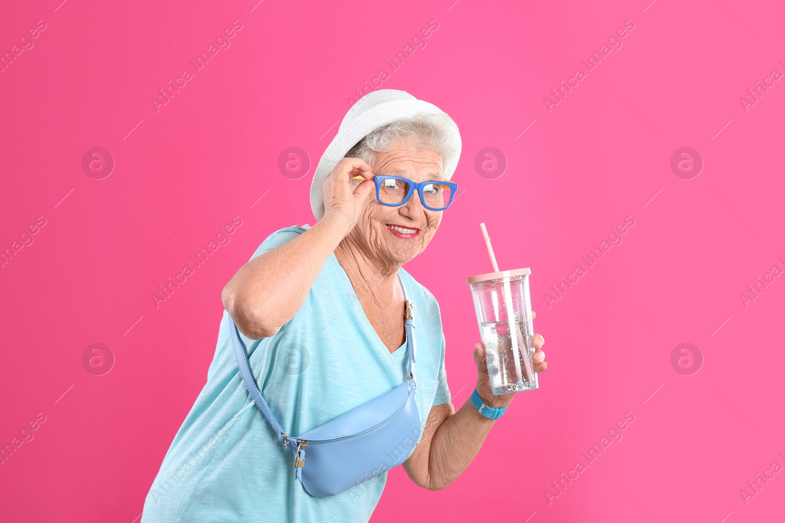 Photo of Portrait of cool grandmother with drink on color background, space for text