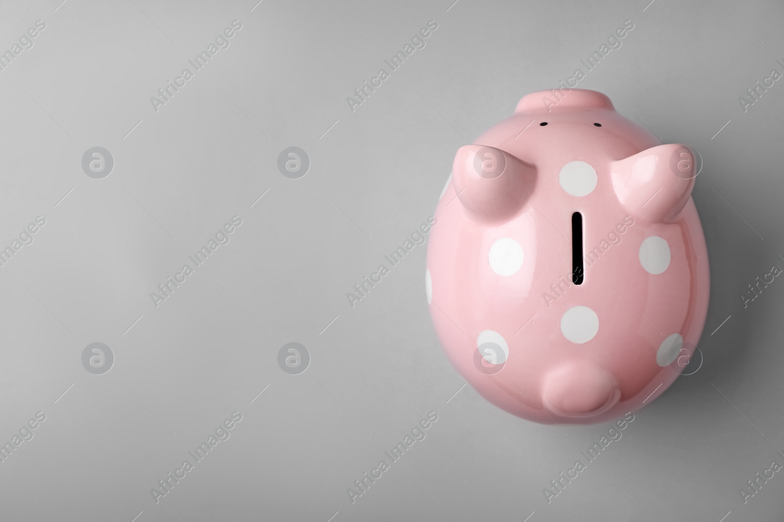 Photo of Pink piggy bank on gray background, top view