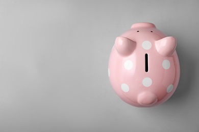 Photo of Pink piggy bank on gray background, top view