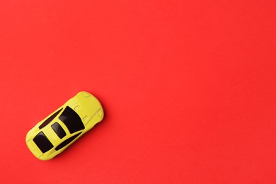 Photo of One yellow car on red background, top view. Space for text