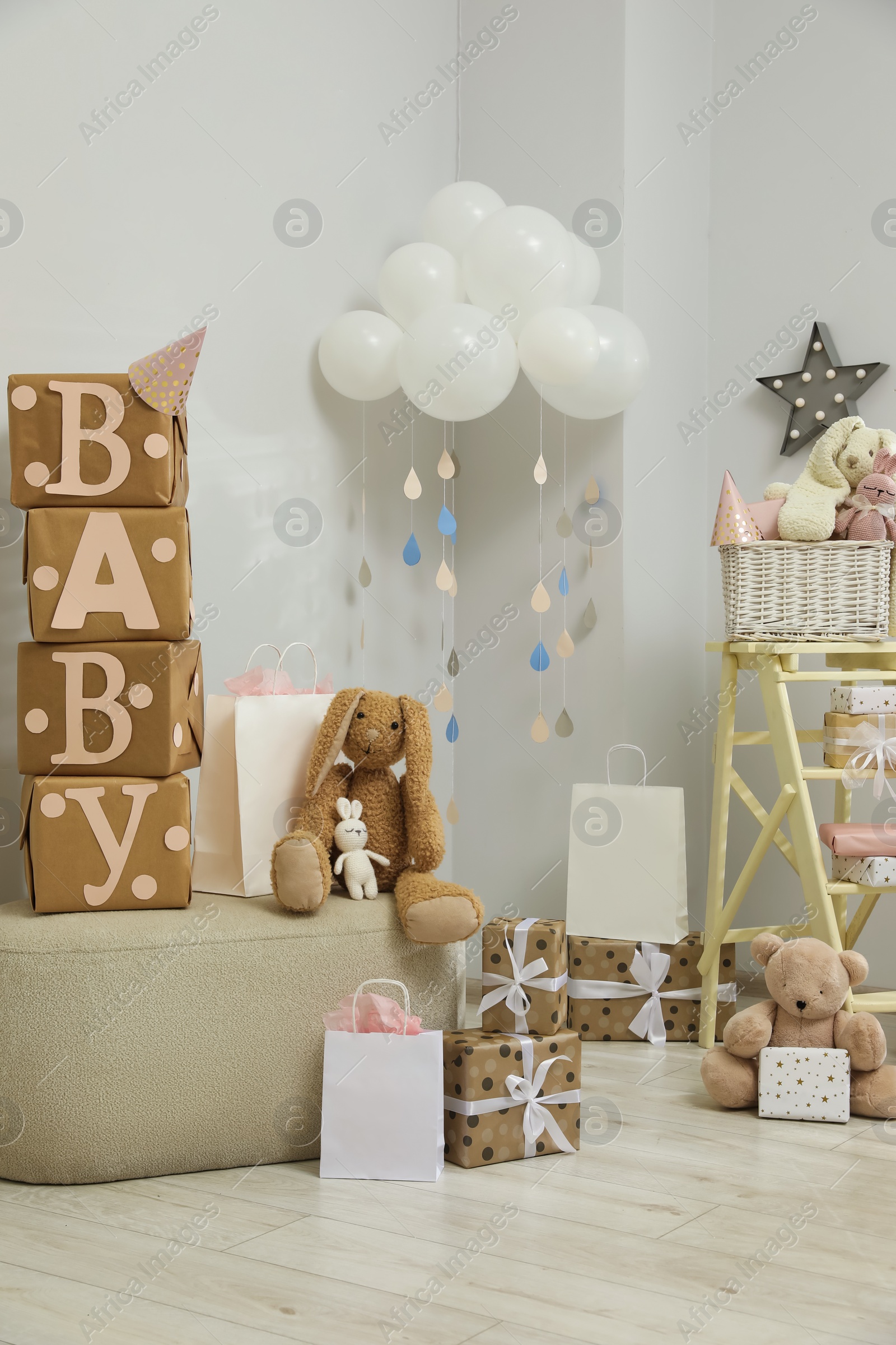 Photo of Baby shower party. Festive decor, gift boxes and toys in stylish room