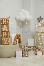 Photo of Baby shower party. Festive decor, gift boxes and toys in stylish room