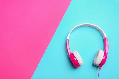 Stylish headphones on color background, top view. Space for text