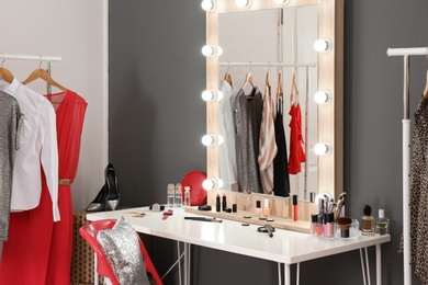 Photo of Stylish room with dressing table, mirror and wardrobe rack