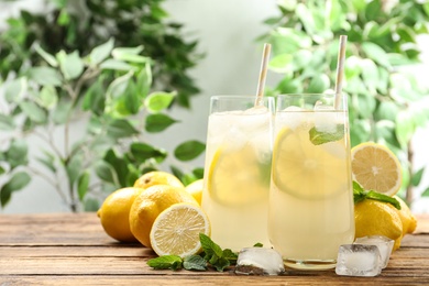 Natural lemonade with mint on wooden table, space for text. Summer refreshing drink