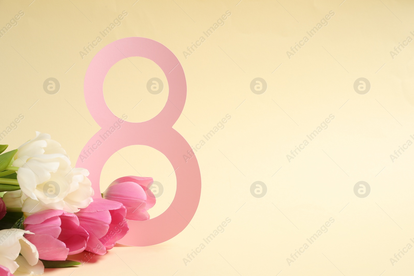 Photo of 8 March greeting card design with beautiful tulips on light yellow background. Space for text