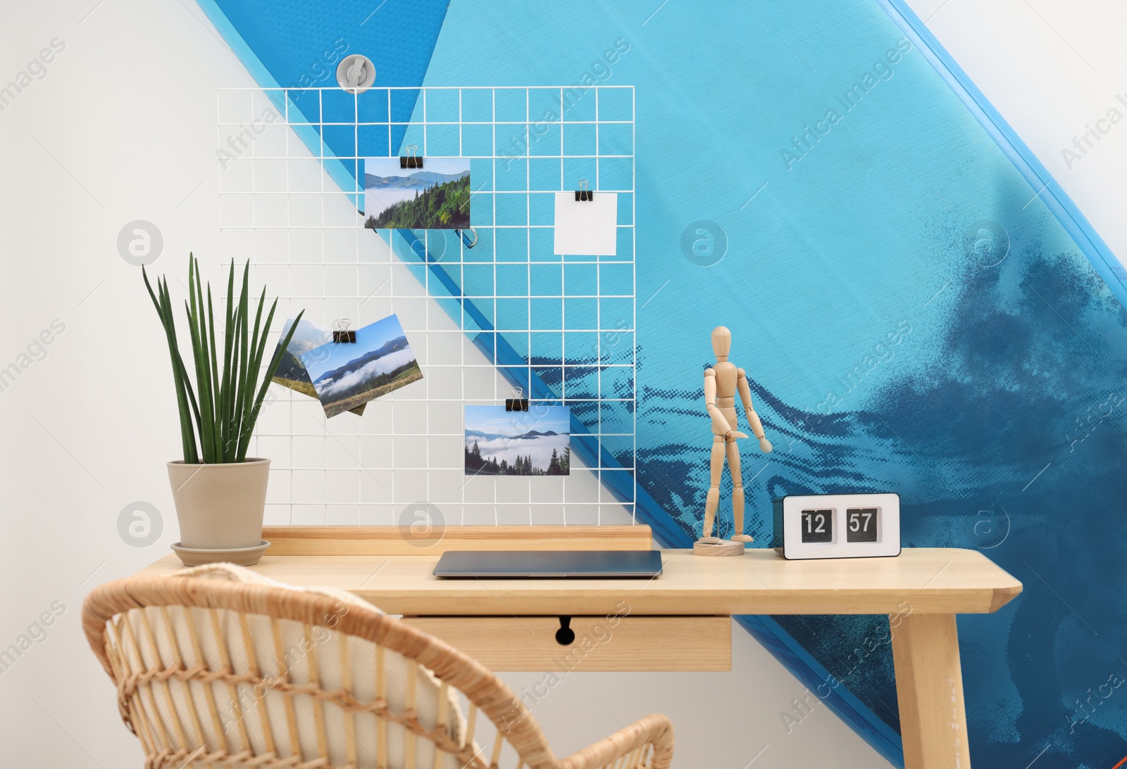 Photo of SUP board and workplace in room. Interior design