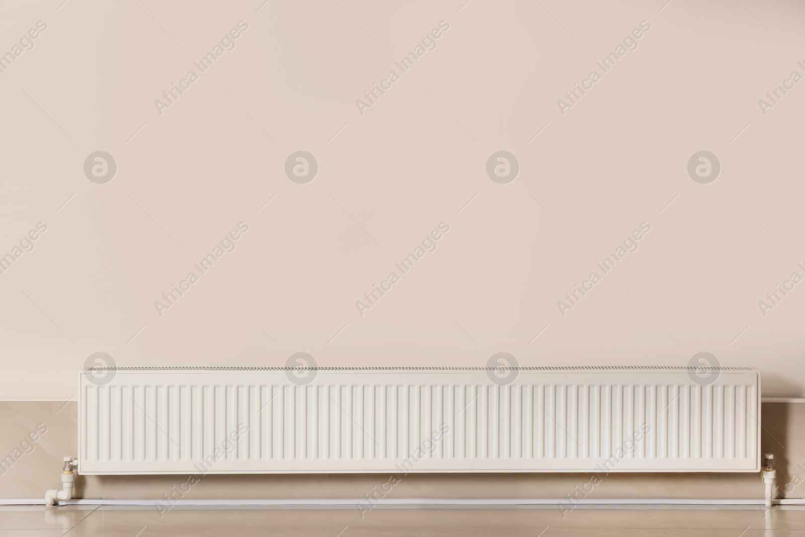 Photo of Heating radiator in empty room against closed window