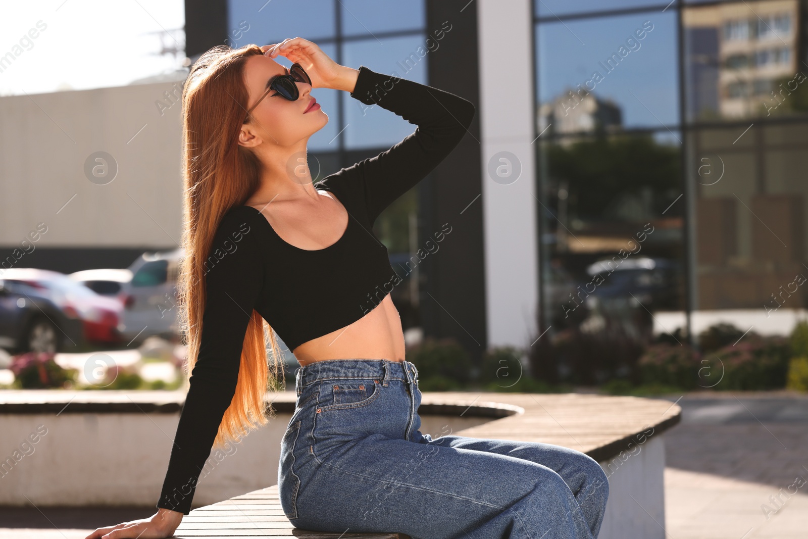 Photo of Beautiful woman in sunglasses on city street, space for text