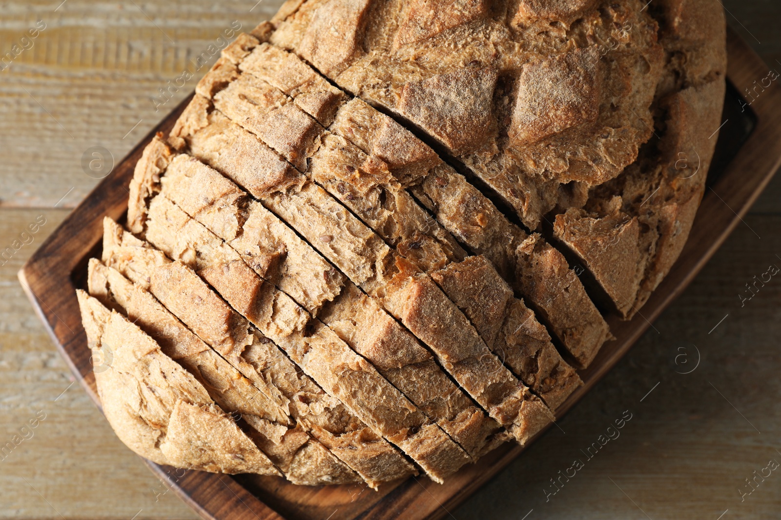 Photo of Freshly baked cut sourdough bread on wooden table