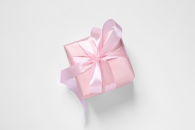 Photo of Beautiful gift box with pink bow on white background, top view