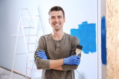 Photo of Portrait of male decorator with brush indoors