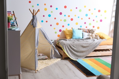Modern child room interior with bed and play tent