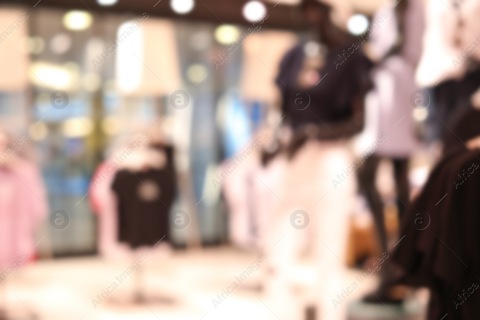 Photo of Blurred view of modern store with different clothes