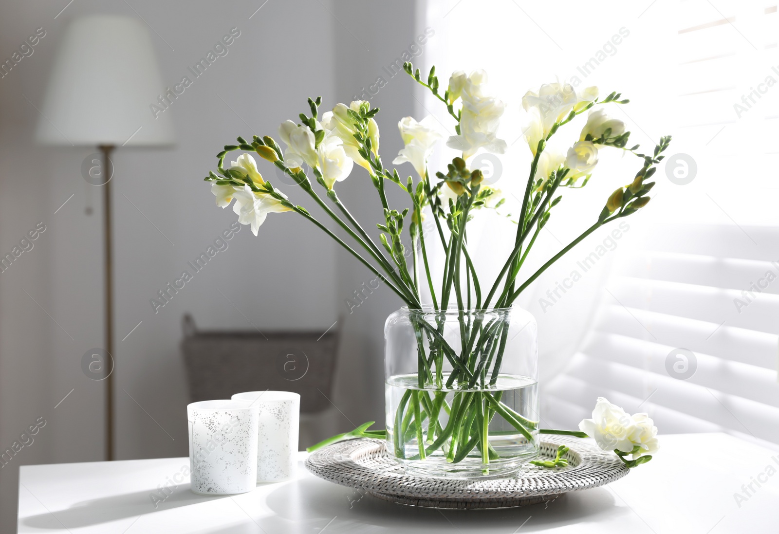 Photo of Beautiful spring freesia flowers on table in room