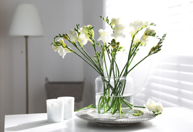 Beautiful spring freesia flowers on table in room