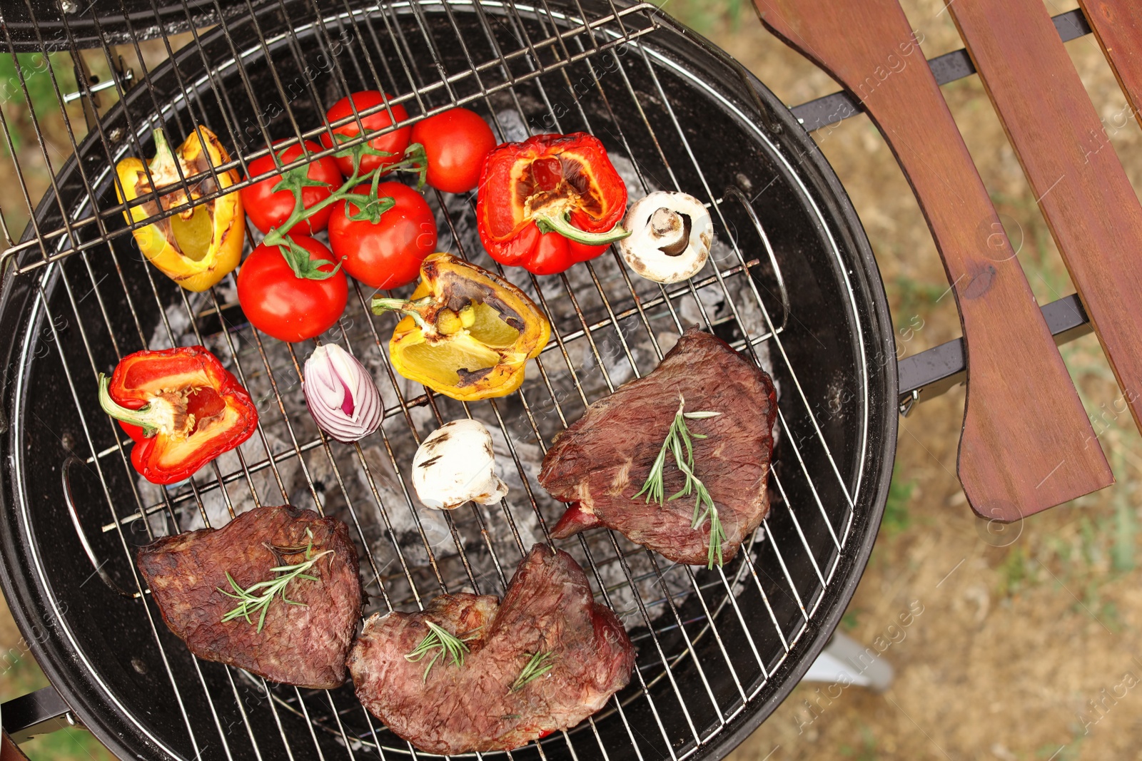 Photo of Modern grill with meat and vegetables outdoors, top view
