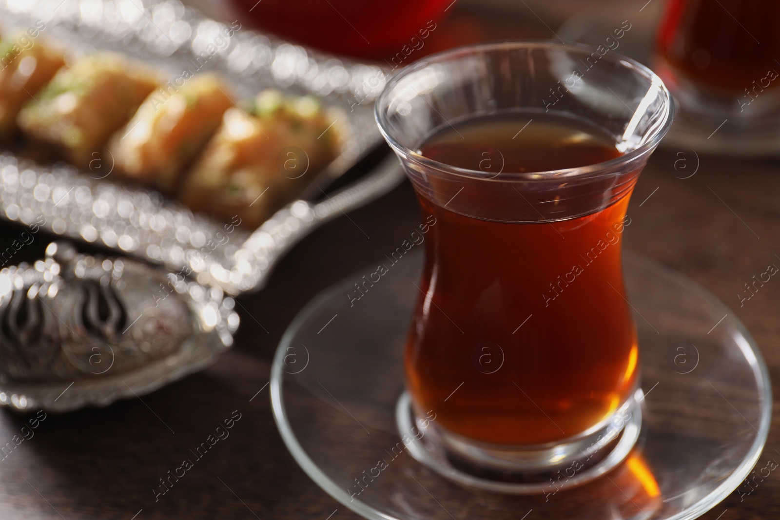 Photo of Traditional Turkish tea in glass on wooden table, closeup. Space for text