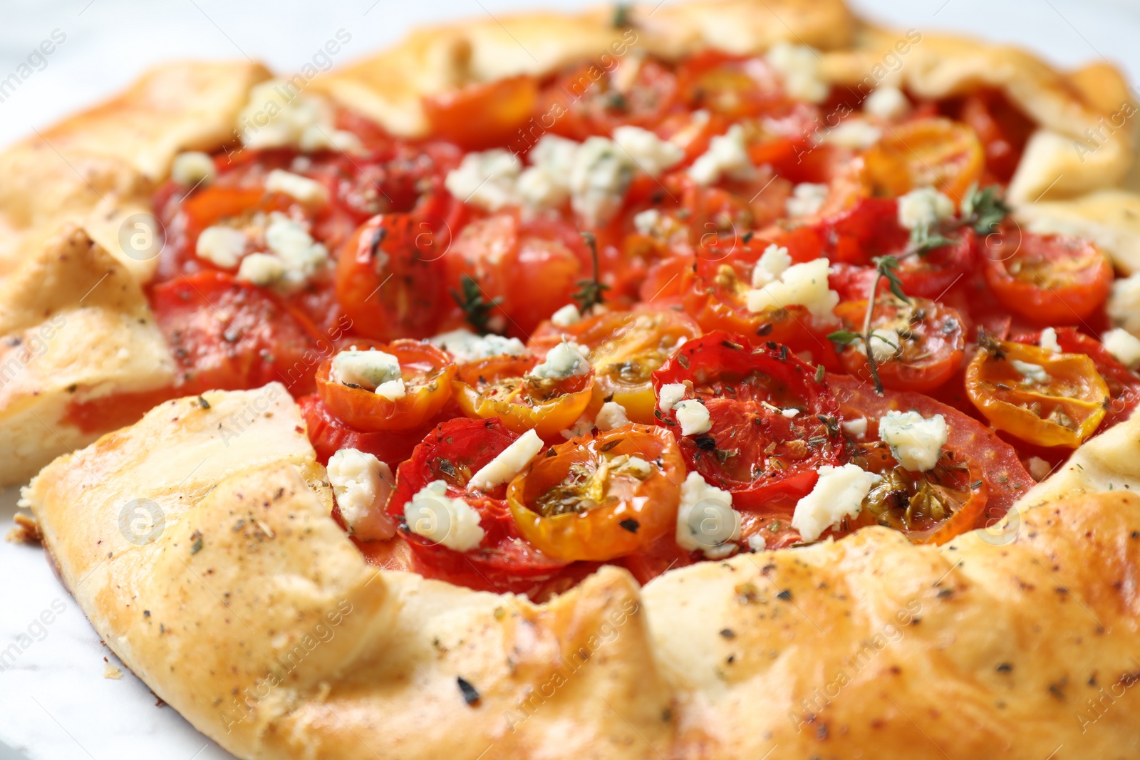 Photo of Tasty galette with tomato, thyme and cheese (Caprese galette) on table, closeup