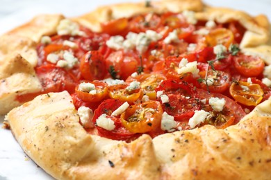 Photo of Tasty galette with tomato, thyme and cheese (Caprese galette) on table, closeup