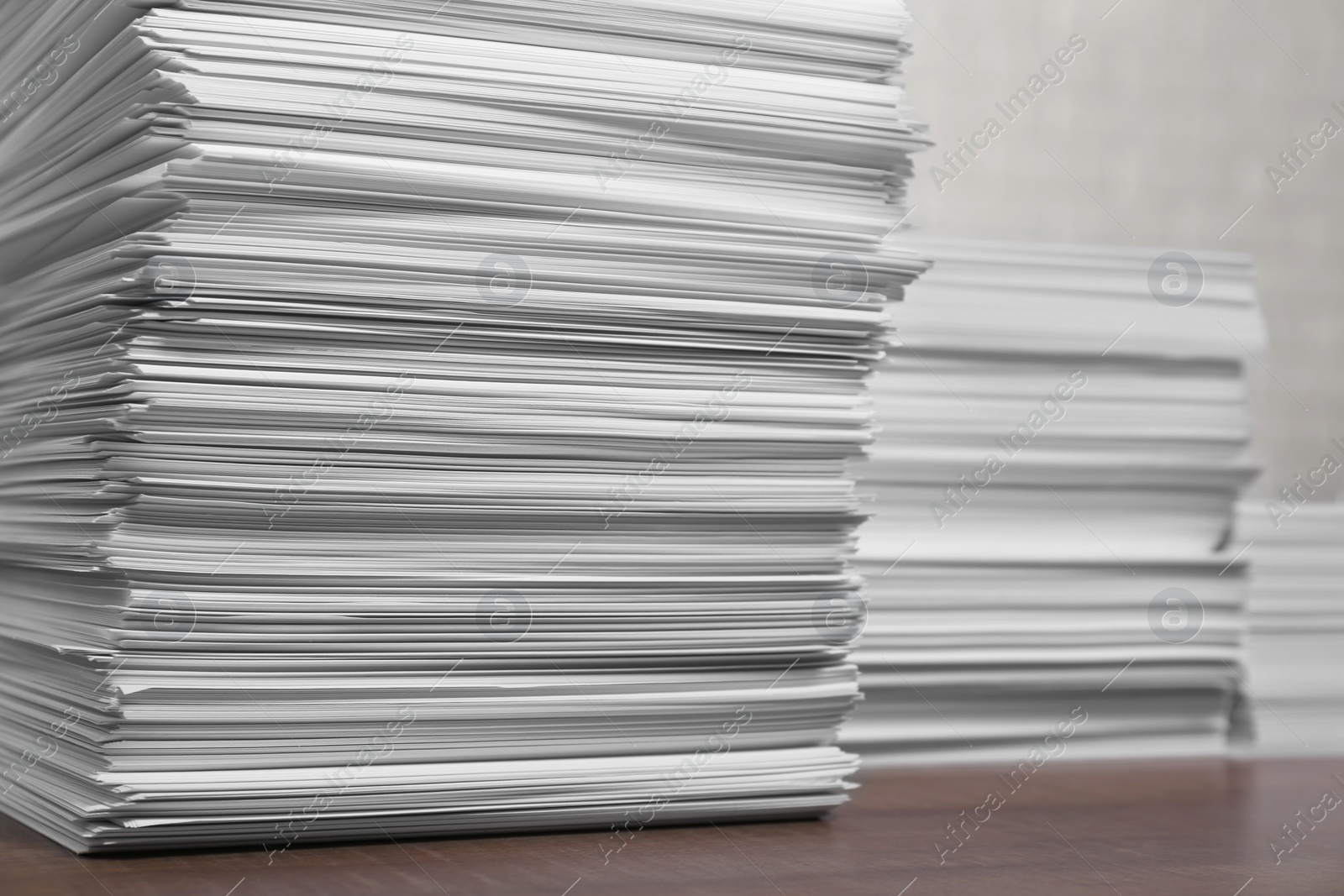 Photo of Stacks of white paper sheets on wooden table