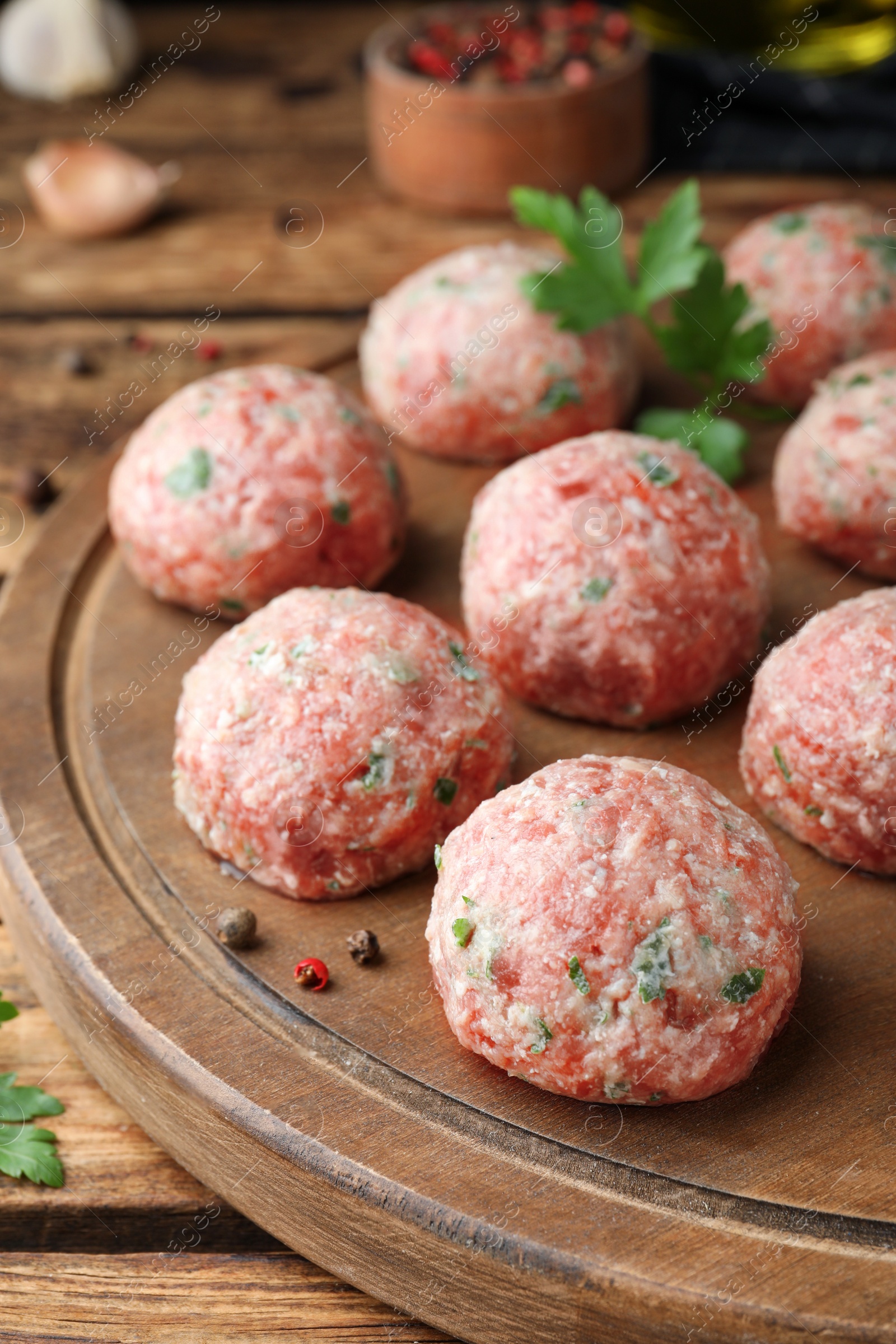 Photo of Many fresh raw meatballs on wooden table