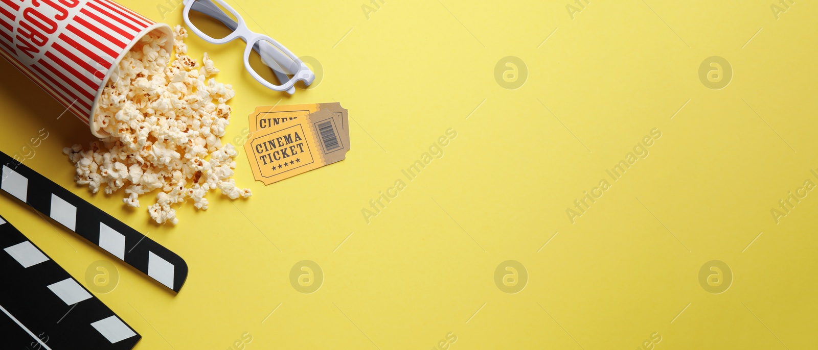 Image of Flat lay composition with delicious popcorn and glasses on yellow background, space for text. Banner design