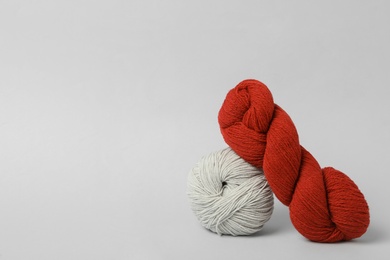 Photo of Soft woolen yarns on white background, space for text
